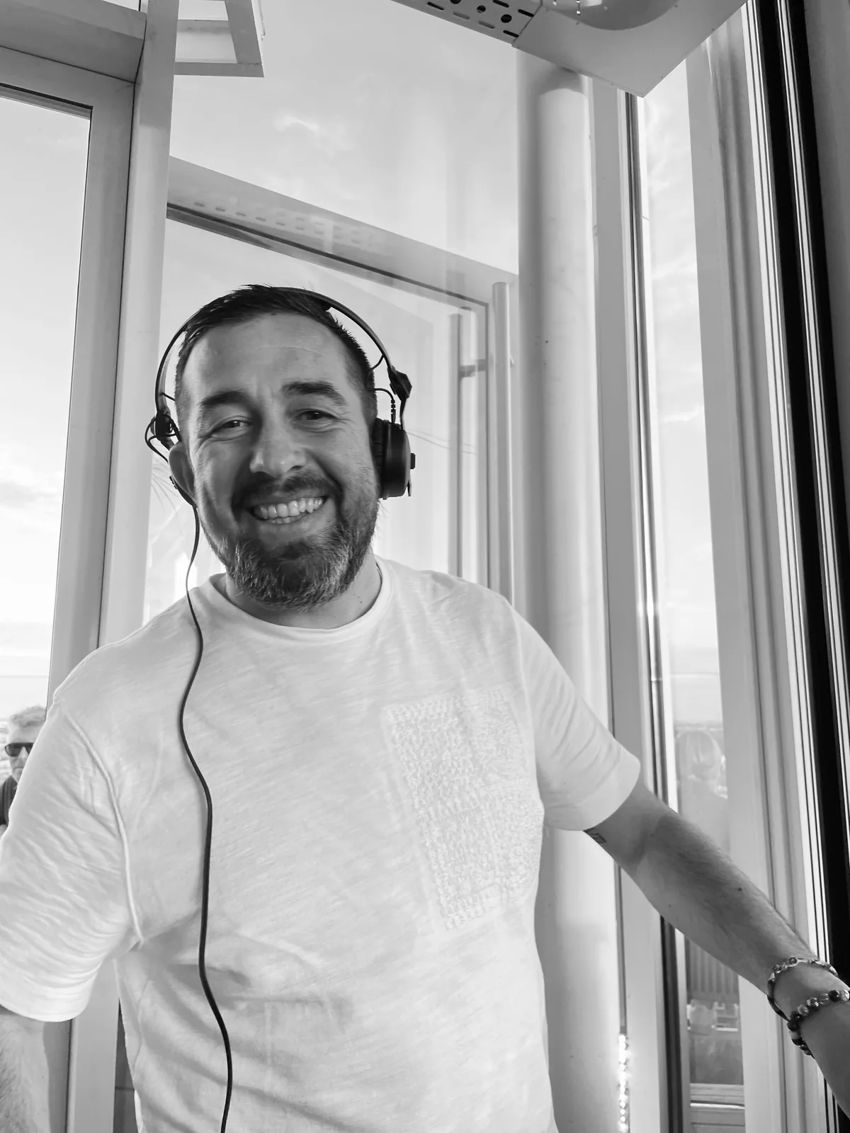 Black-and-white portrait of BiNBiN smiling with headphones